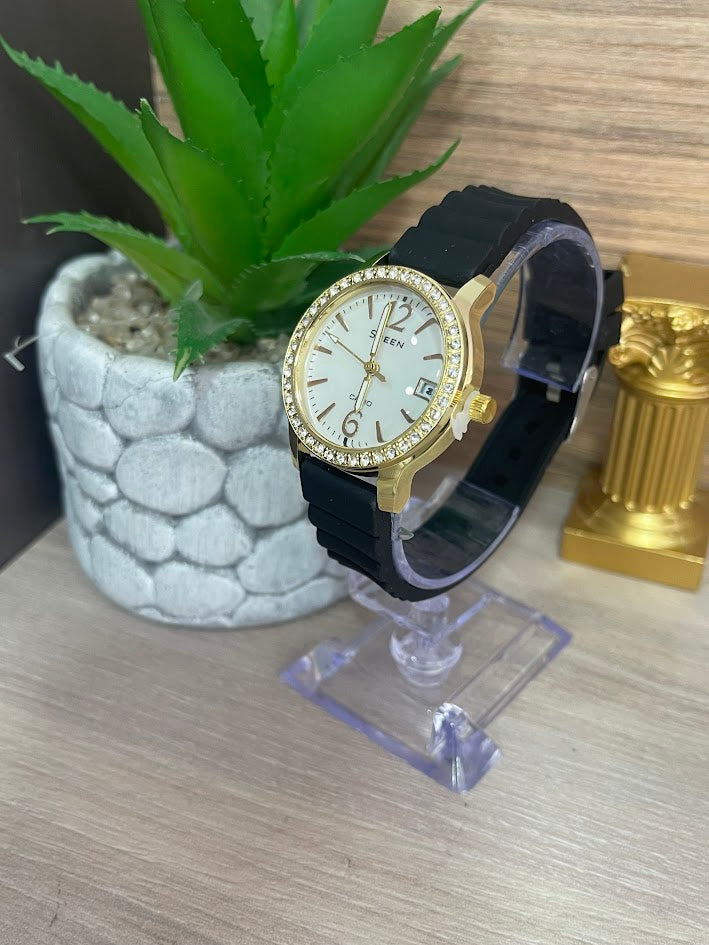 RELOJ SHEEN DAMA DORADO MANILLA DE SILICONA FONDO BLANCO CON CALENDARIO