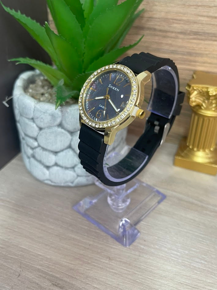 RELOJ SHEEN DAMA DORADO MANILLA DE SILICONA FONDO AZUL CON CALENDARIO