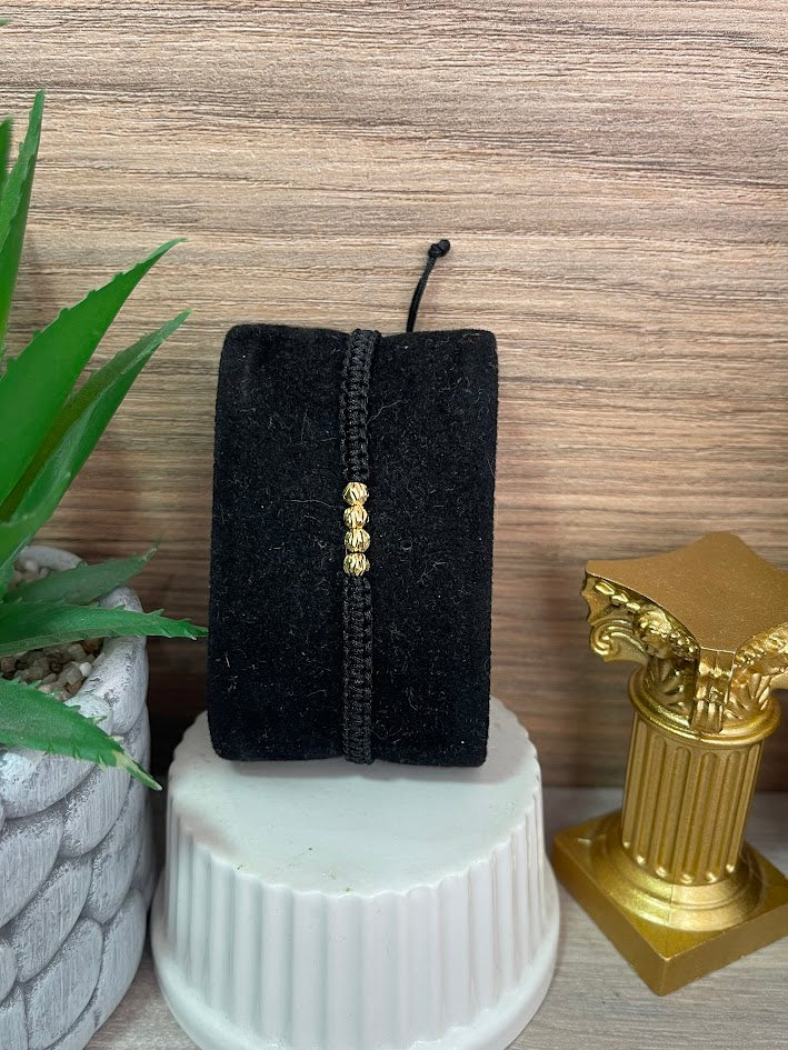 PULSERA TEJIDA NEGRA 4 BALINES ORO LAMINADO