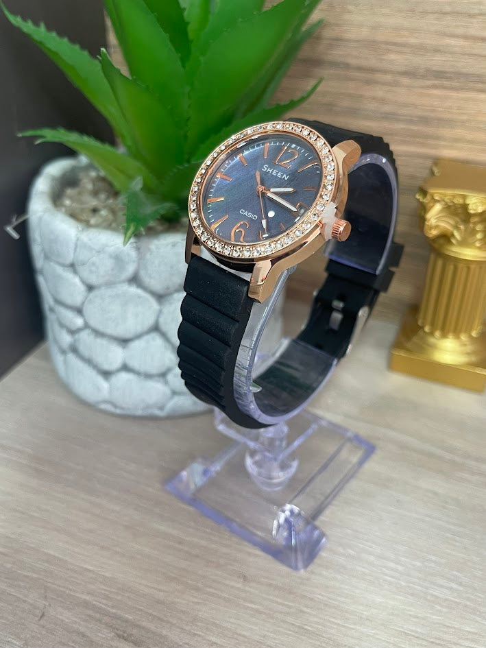 RELOJ SHEEN DAMA ORO ROSA MANILLA DE SILICONA FONDO AZUL CON CALENDARIO